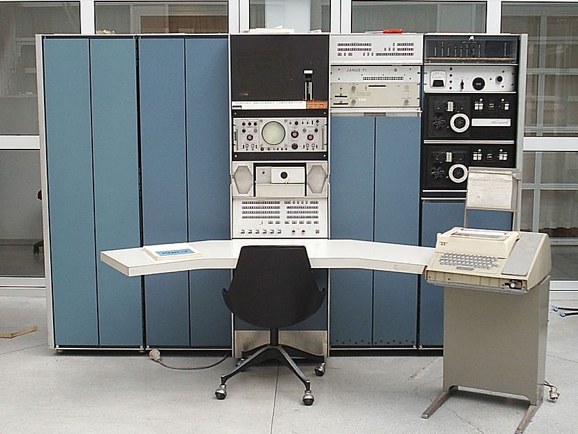 Et rom med en stol foran en gammel diger datamaskin.